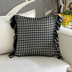 Cojín negro decorativo sobre sillón estilo moderno y acogedor