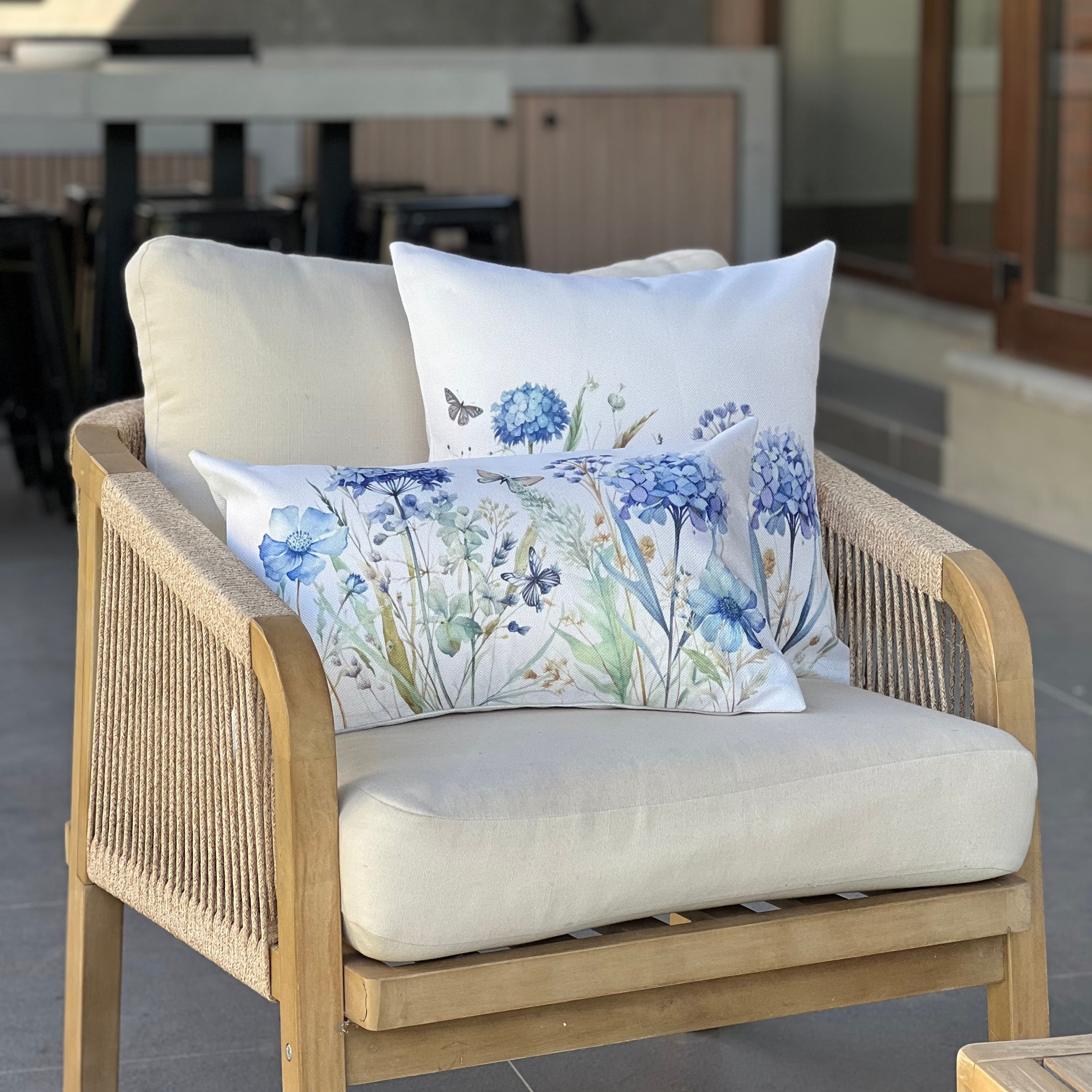 Cojín decorativo con estampado de hortensias azules sobre cama estilo elegante y acogedo