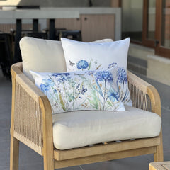 Cojín decorativo con estampado de hortensias azules sobre cama estilo elegante y acogedo
