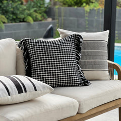 Cojín negro decorativo sobre sillón gris estilo moderno y acogedor